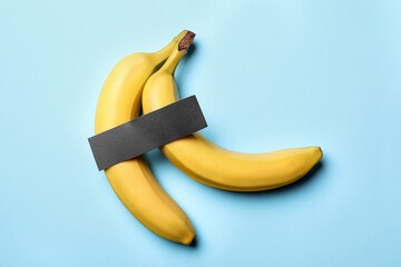 Bananas with censor bar on turquoise background, flat lay