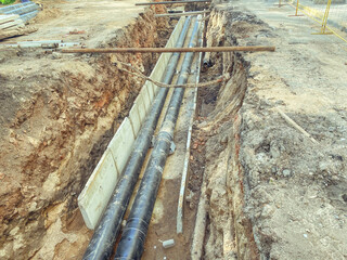 laying of underground communications for residential buildings. black plumbing pipes made of...