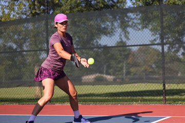 Pickleball being played, outdoors, by ladies.