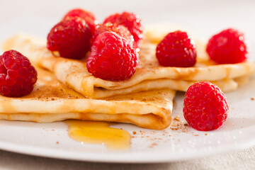 delicious pancakes with fresh raspberries and honey