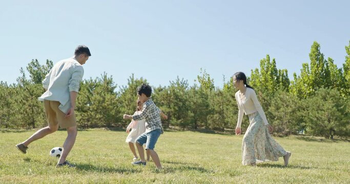 Happy family playing football in park,4K