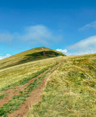 Fototapeta premium mountain landscape top of a mountain against a blue sky with clouds, view wallpaper carpathians place for text tourism hiking
