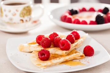 breakfast of pancakes with fresh raspberries on table
