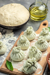 Cutting board with raw khinkali with meat, semi-finished products dumplings. cooking khinkali. National Georgian cuisine. vertical image. top view