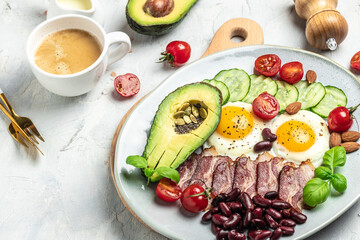 Keto breakfast with avocado, fried eggs, bacon, and beans. paleo keto breakfast diet lunch. Healthy nutritious paleo keto breakfast concept. Food recipe background. Close up