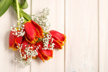 Orange tulips on wooden background, copy space.
