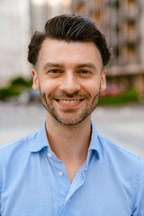Fototapeta premium Bristle white man smiling at camera while standing at city street