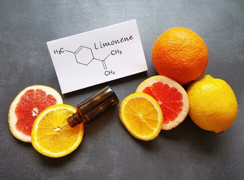 Structural chemical formula of limonene with fresh citrus fruit and a glass cosmetic bottle. Limonene is an essential oil found in the peel of citrus fruits, such as lemons, oranges, grapefruits.
