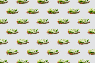 Seamless pattern of sandwiches with kiwi and soft cheese on a white background. Modern minimal food photography collage. Morning breakfast brunch concept.