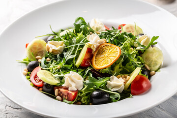 Fresh greek salad arugula, cream cheese, pine nuts, tomato, black olives and cucumber. healthy vegan lunch bowl. banner, menu recipe place for text, top view