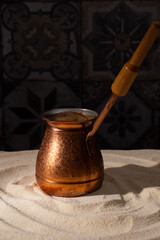 traditional Turkish coffee in a copper pot on hot sand