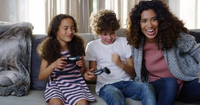 Family, game and fun of kids or siblings playing competitive console video games at home by mother. Happy, smile and children on sofa gaming together in the house with gamer boy and girl love.