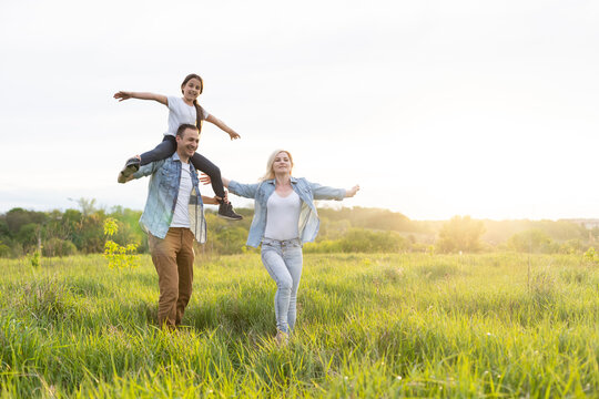 Young Happy Family In A Field