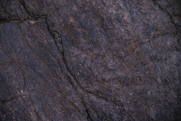 Stone black textured background. Natural stone. The black background is a blank for the design. Uneven surface.