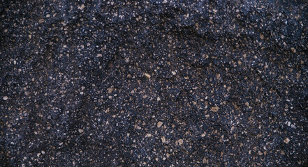 Stone black textured background. Natural stone. The black background is a blank for the design. Uneven surface.