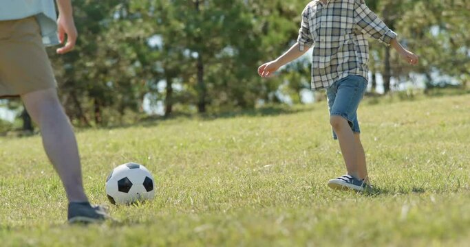 Happy father and son playing football in park,4K