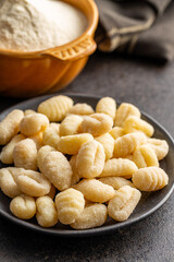 Uncooked potato gnocchi on plate. Tasty italian food.