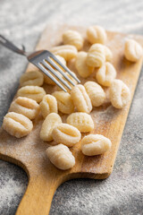 Uncooked potato gnocchi on cutting board. Tasty italian food.