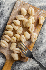 Uncooked potato gnocchi on cutting board. Tasty italian food.