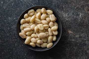 Uncooked potato gnocchi in bowl. Tasty italian food.