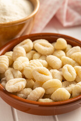 Uncooked potato gnocchi in bowl. Tasty italian food.