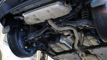 Car in a car service on a lift. Bottom view of the rear of the car. Selected focus.