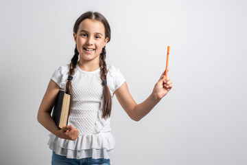 Lovely little girl standing and holding book over white background