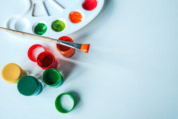 Brush and tubes of paint on a white background, space for text