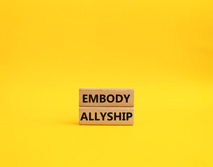 Embody Allyship symbol. Concept word Embody Allyship on wooden blocks. Beautiful yellow background. Business and Embody Allyship concept. Copy space