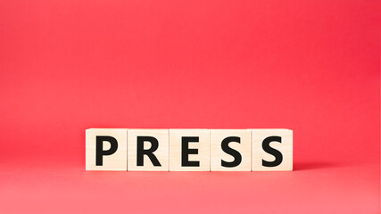 Press symbol. Wooden cubes with word Press . Beautiful red background. Press concept. Copy space.