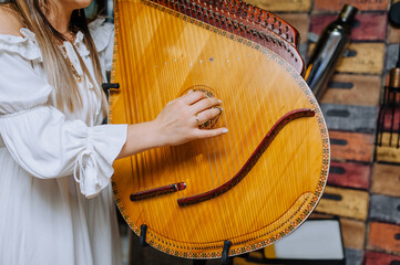 A girl musician in an embroidered shirt plays the bandura, a musical Ukrainian national traditional...