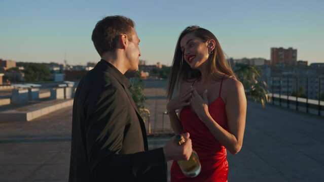 A man arranged a romantic udin for his woman on the roof of the house, in the patio area with champagne and fruits at sunset. Love, romantic ideal relationship, surprise