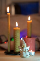 A statuette of an angel on the background of burning candles. The concept of a holiday, goodness and light