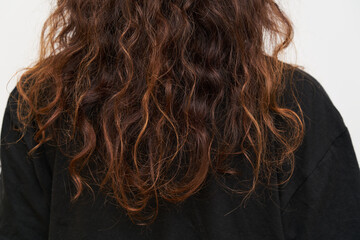 Naklejka premium Dry and frizzy natural curly hair that needs hydration. Natural curls before salon treatment. close up.