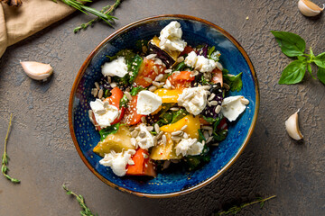 Salad with baked aubergines and feta cheese with tomatoes top view on brown concrete table