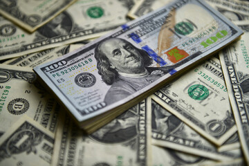 Currency war concept, Global economic crisis situation. A heap of one hundred dollar bills on The US currency notes. Shallow depth of field. Selective focus.