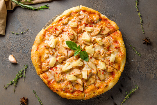 Pizza Hawaiian With Pineapple And Chicken On Brown Concrete Table Top View