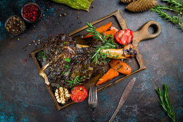 Leg of lamb baked with vegetables on the board top view © Алиса Королевская