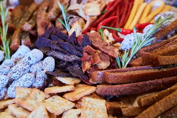 Assortment of a large number of different delicacies. Cheeses, sausages, canned food and bread, herbs and sauces.