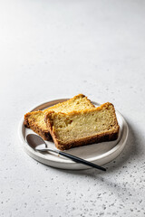 Two slices of pumpkin bread on white plate on gray background. Autumn dessert with space for text