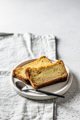 Two slices of pumpkin bread on white plate on linen napkin gray background. Autumn dessert with space for text