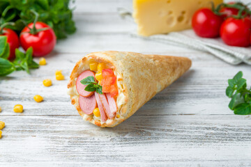 pizza in a cone цшер sausages, corn and tomatoes on white wooden table