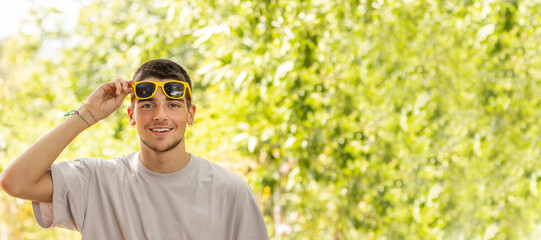 Naklejka na ściany i meble portrait of young man with sunglasses outdoors