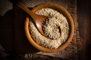 Sesame seeds spoon on old background