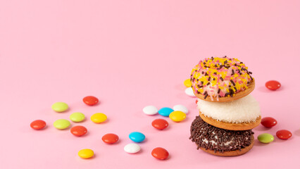 Colored dragees and cakes with confectionery decor - background with sweets