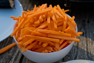 Bowl full of orange carrot sticks. Close up. Selective focus.