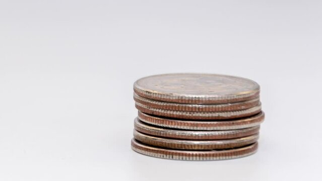 stop motion reduces the stack of coins on a white background. Concept: falling incomes, financial crisis.