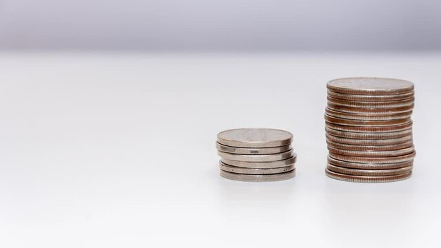 stop motion reduces the stack of coins on a white background. Concept: falling incomes, financial crisis.