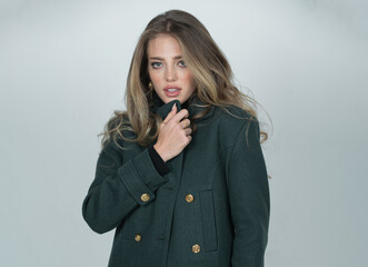 Fashion female coat. Young glamour woman wearing stylish fashion dress. Fashion model in studio.