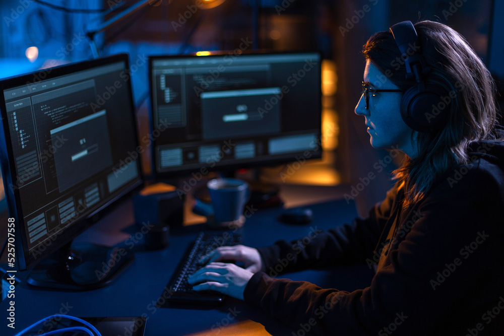 Poster cybercrime, hacking and technology concept - female hacker in dark room writing code or using comput